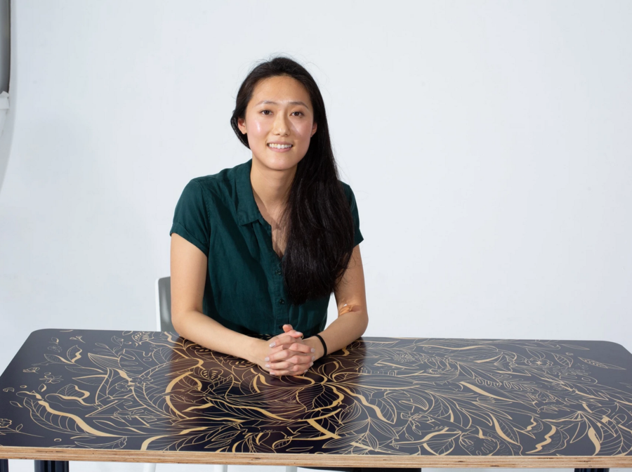 Chassie designer Ivy Tai sits atop one of her imaginative desk designs.