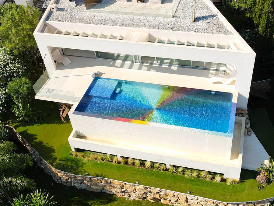 Colorful tiles create a pinwheel design by Felipe Pantone on the bottom of a swimming pool in Javea, Spain.