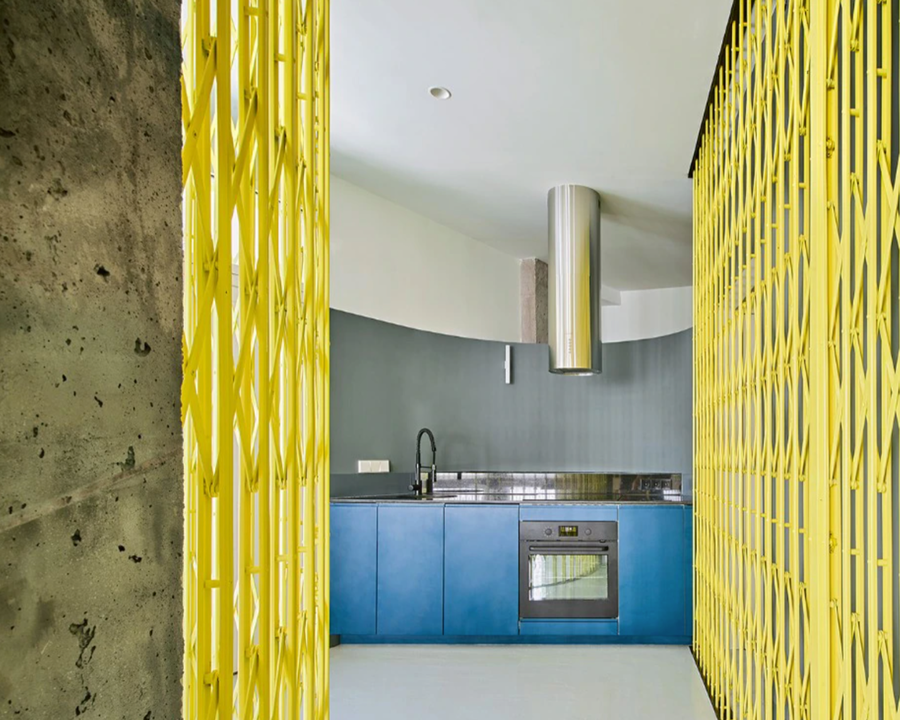 View into VIlla Trap's minimalist kitchen area behind the sliding yellow screen.