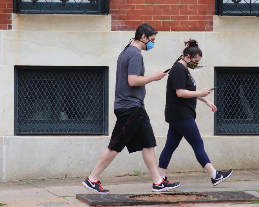 Pedestrians in Baltimore wear protective face masks to help prevent the spread of the novel coronavirus. 
