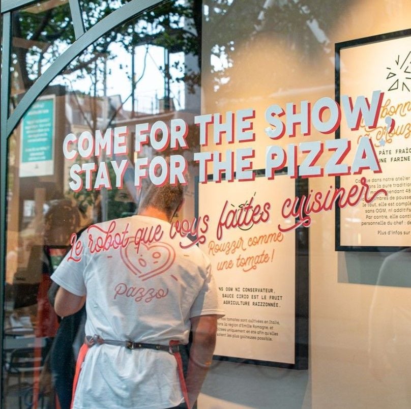 Graphic text outside the Pazzi pizzeria in Paris encourages patrons to 