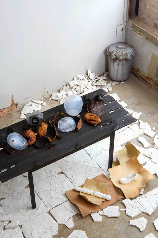 Bruno Baietto's work bench adorned with sparkling sculptural vases and bits of burnt bread cracked open around them.