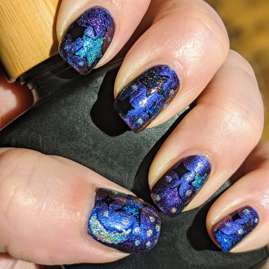 Glittery space-themed nail art. 