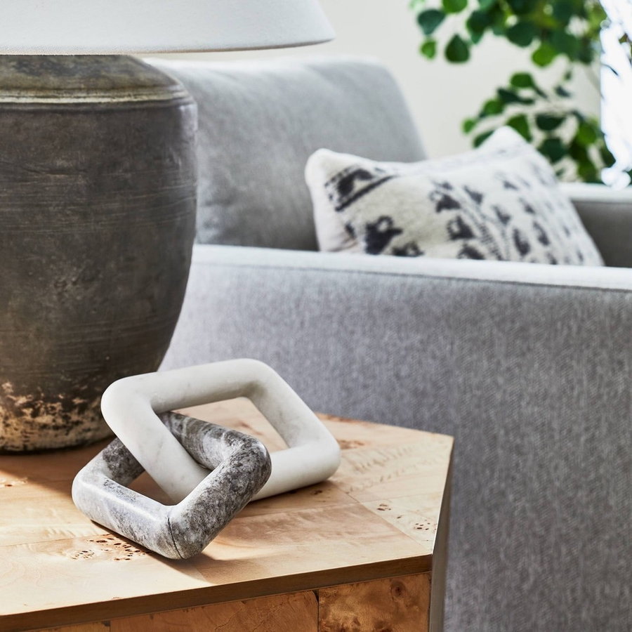 Sculptural marble links from Studio McGee's Spring 2022 furniture collection with Target rest next to a large lamp on an end table.