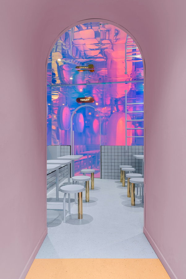 Pastel purple archway leading into the Bun burger joint's surreal mirrored dining room.