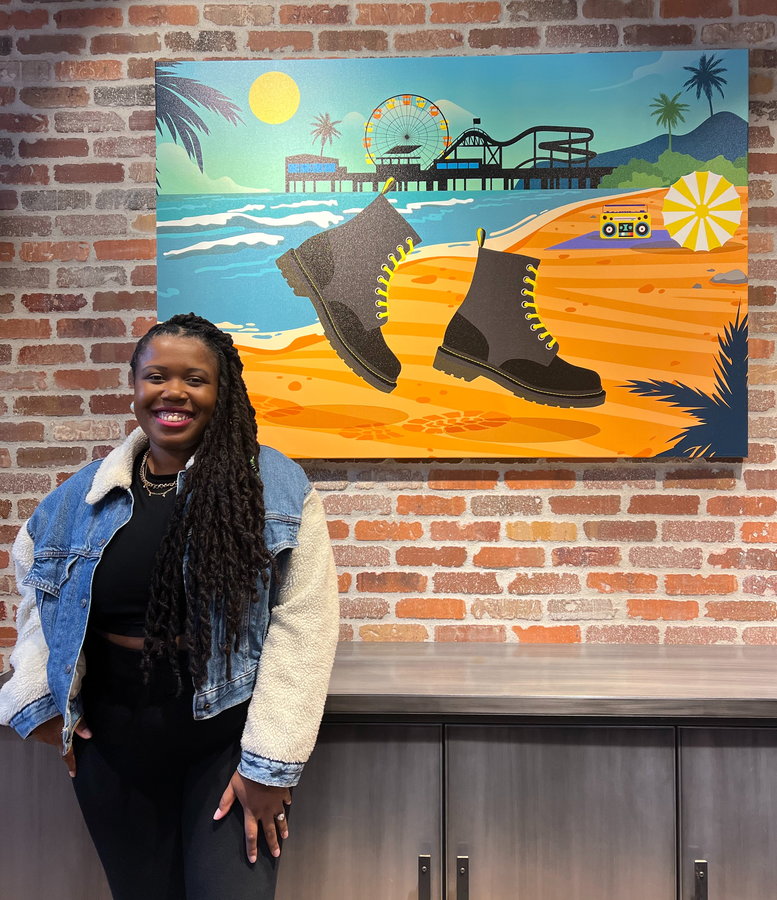 Domonique Brown stands next to a one-of-a-kind artwork she made for the Dr. Martens' store in Santa Monica.