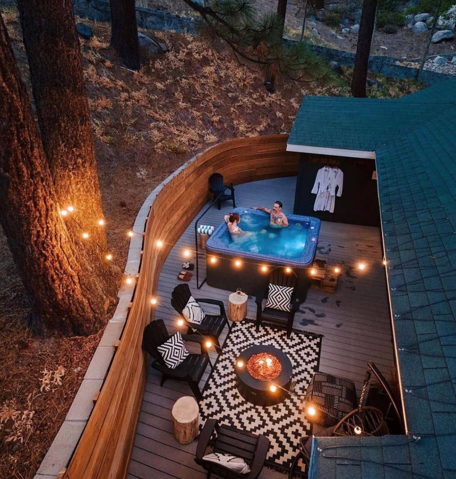 This mostly-wood backyard fully embraces the Friluftsliv spirit with a luxurious hot tub and hanging string lights.