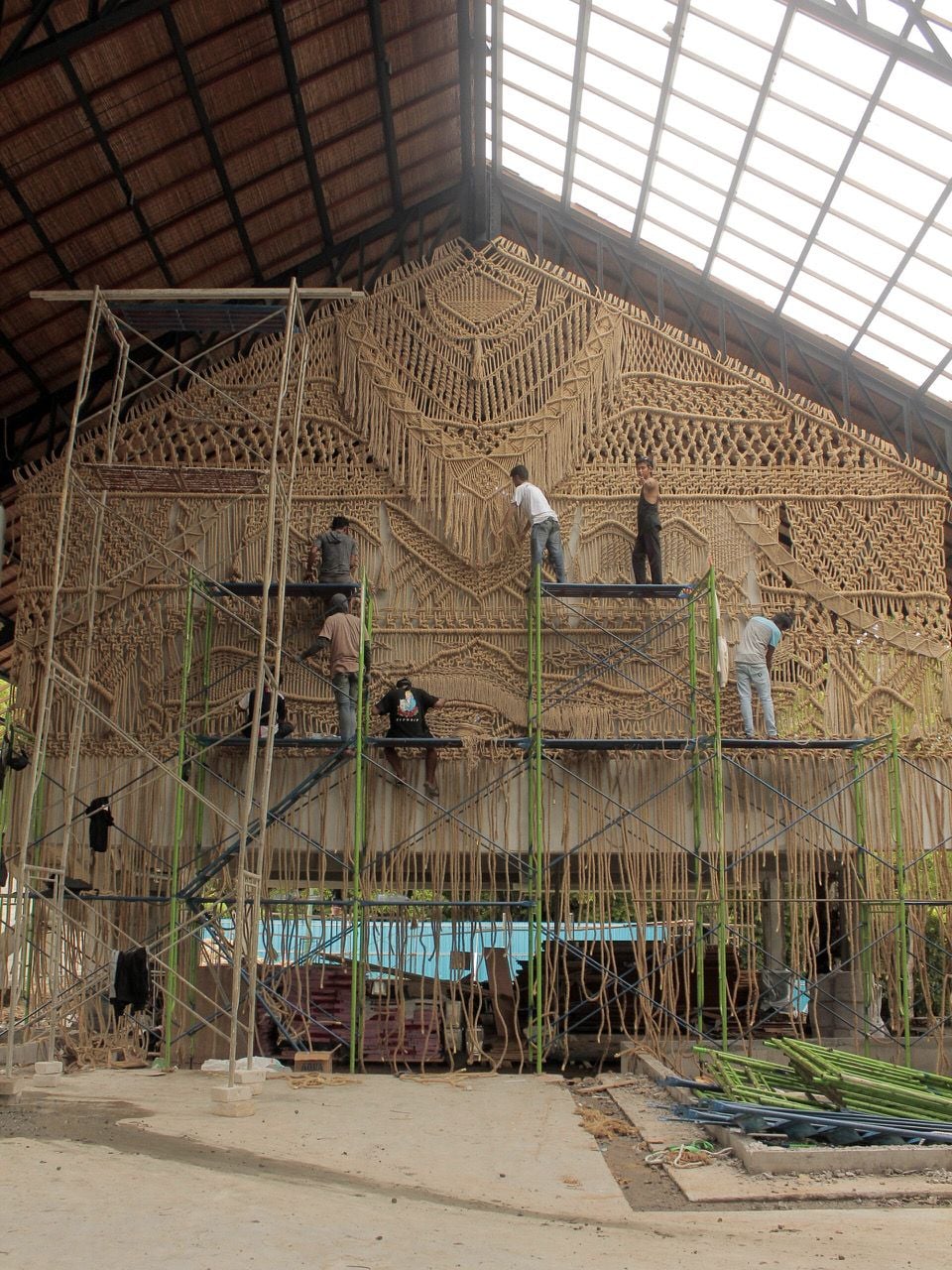 Local artisans work on bamboo scaffolding to finish Agnes Hansella's intricate macrame wall hangings for Locca Beach House Bali. 