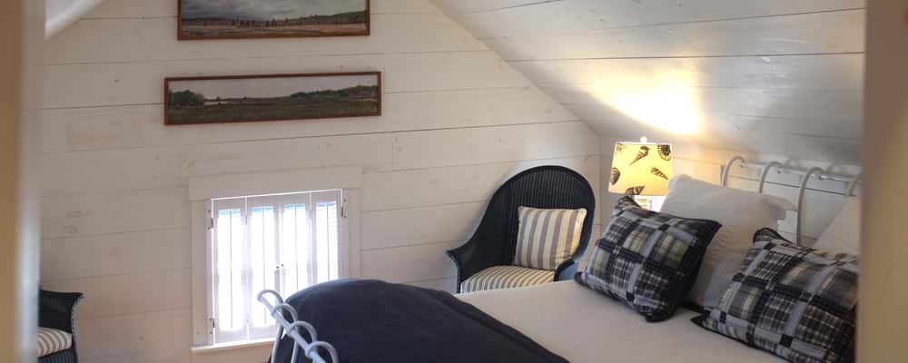 "Nantucket cottage" bedroom with wrought iron, queen bed, AC/heat and white washed walls.  It says...Cape Cod!