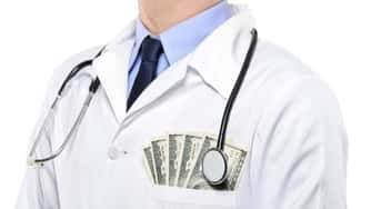 A portrait of a doctor with money in the pocket of his white coat.