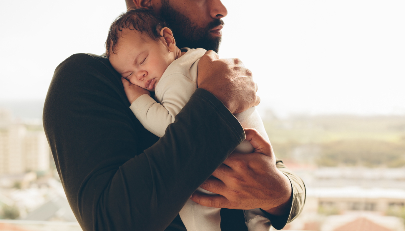 father holding sleeping baby