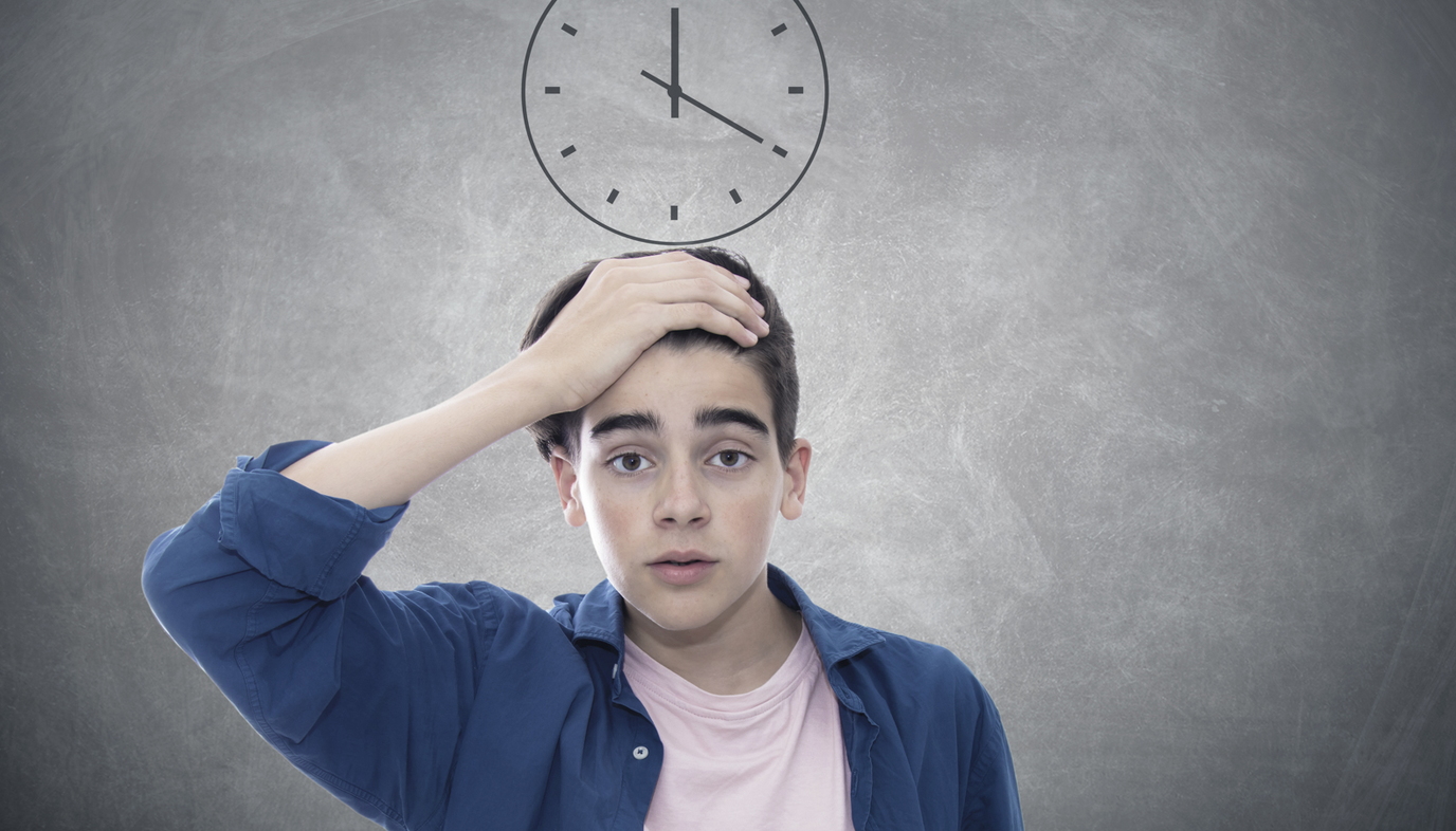 stressed teen standing under clock