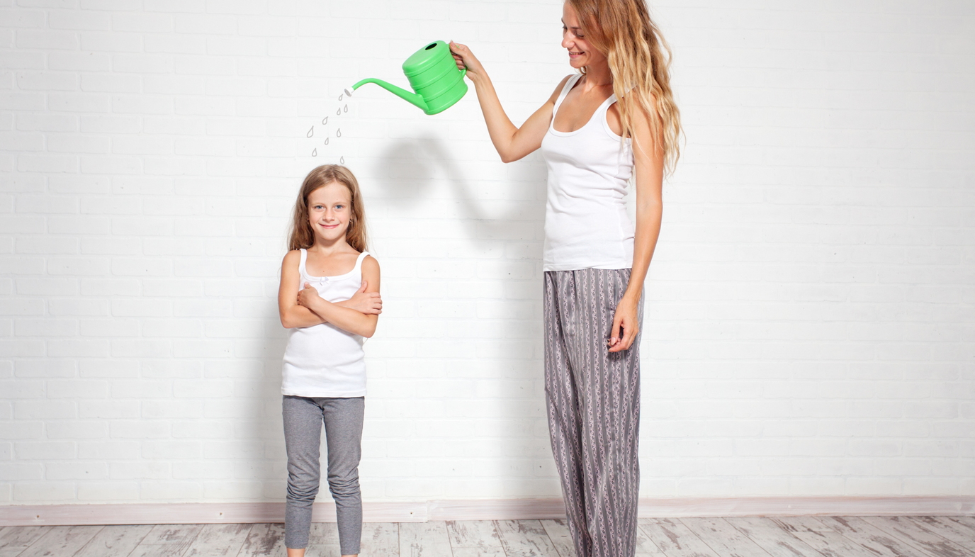 mom with watering can over daughter
