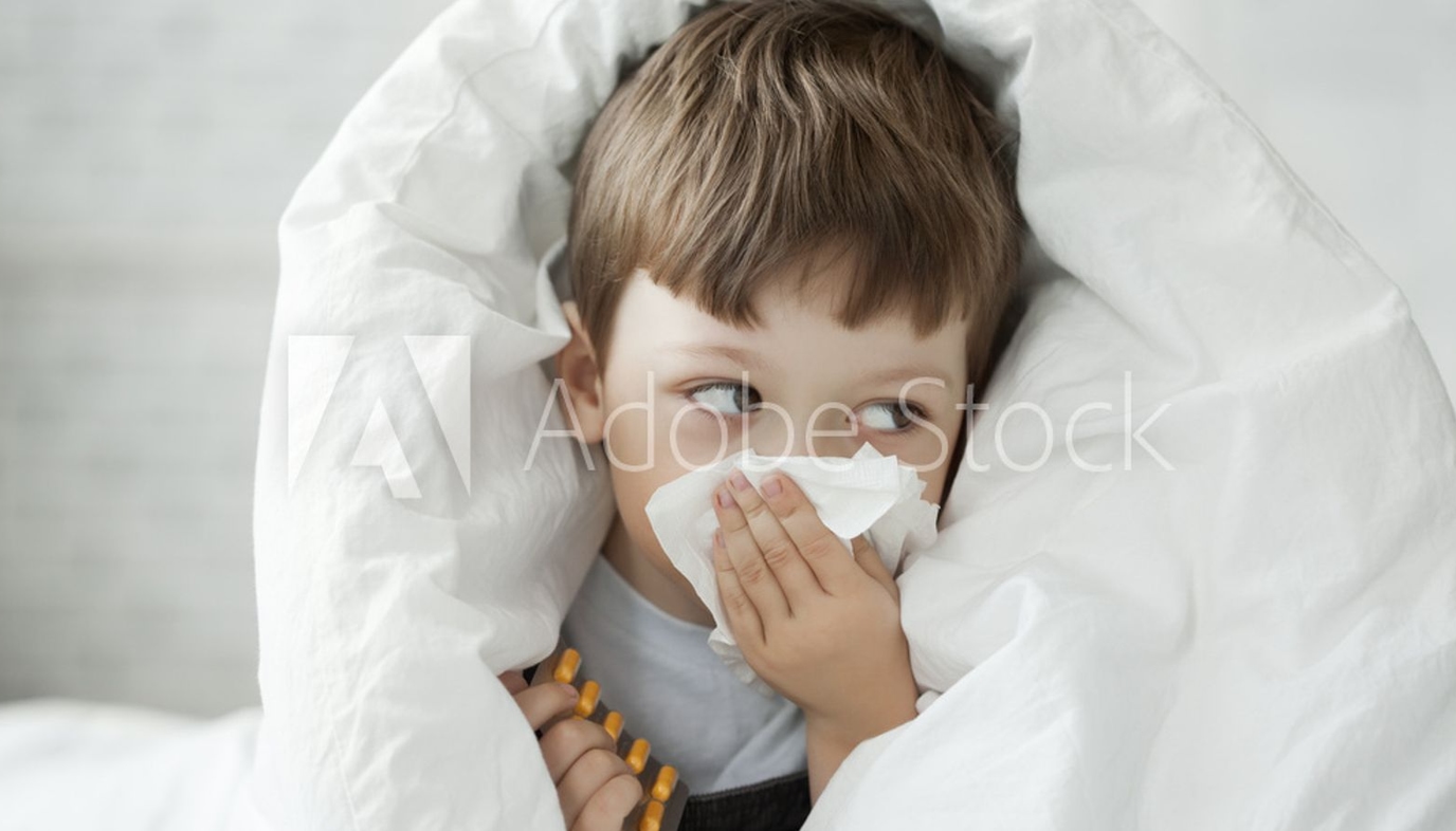 boy wiping nose with tissue