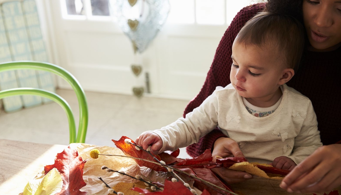 mom and baby playing with fall craft supplies