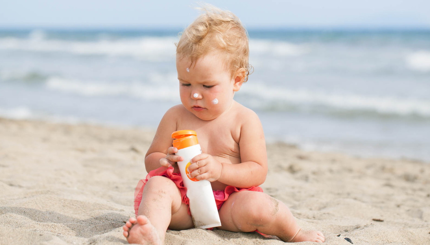 Baby on beach with sun screen