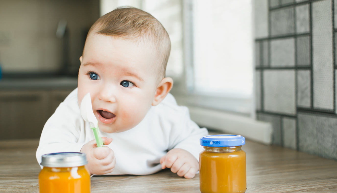 baby with jars of baby food