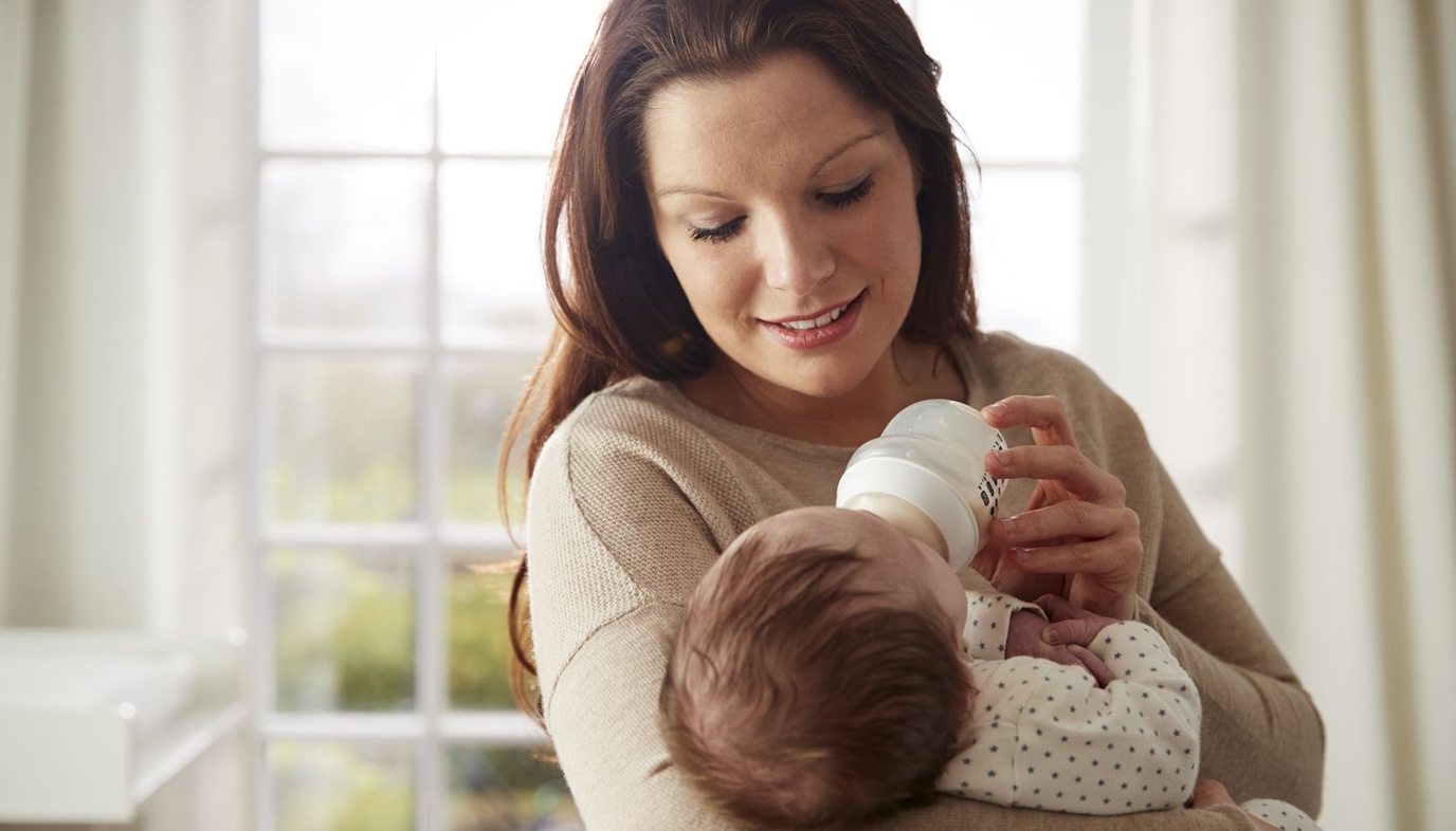 mother feeding baby a bottle