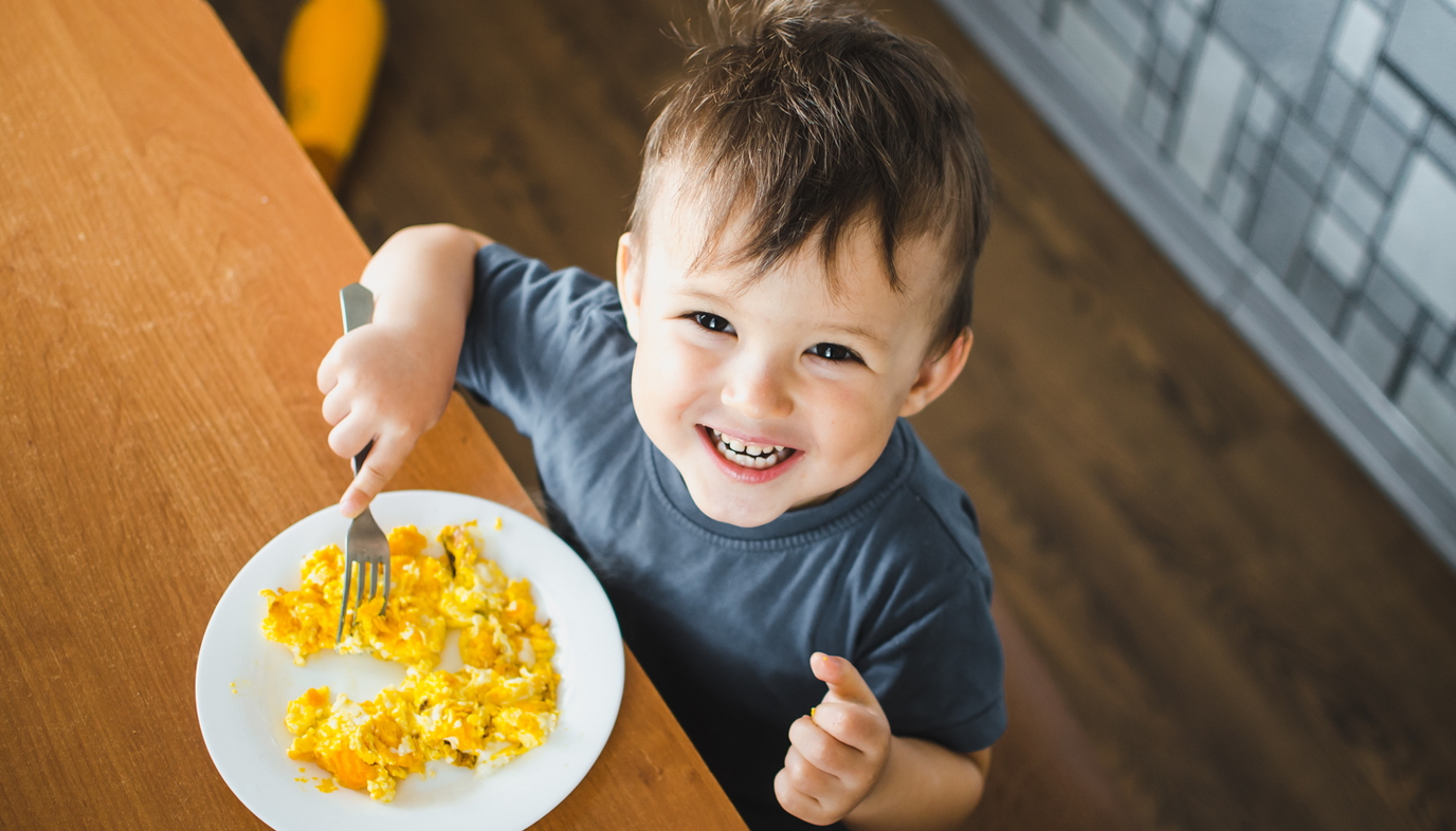 little boy eating scrambled eggs