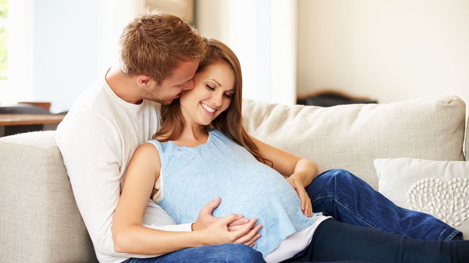 man holding pregnant wife on the couch