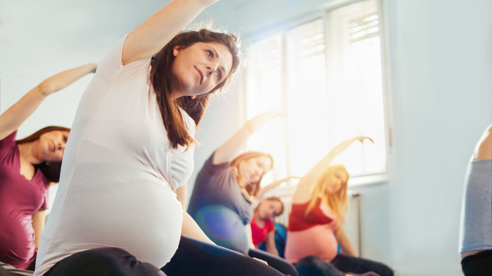 pregnant woman exercising in class