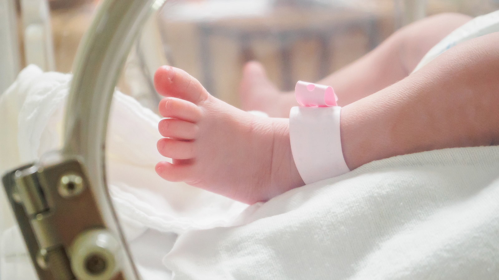 newborn wearing ankle bracelet name tag