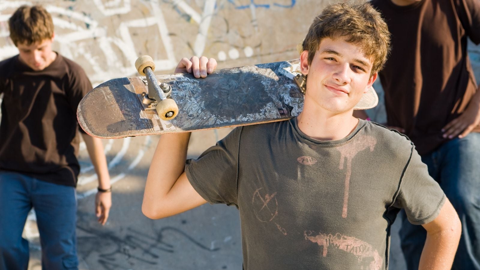 teenage boy holding skateboard