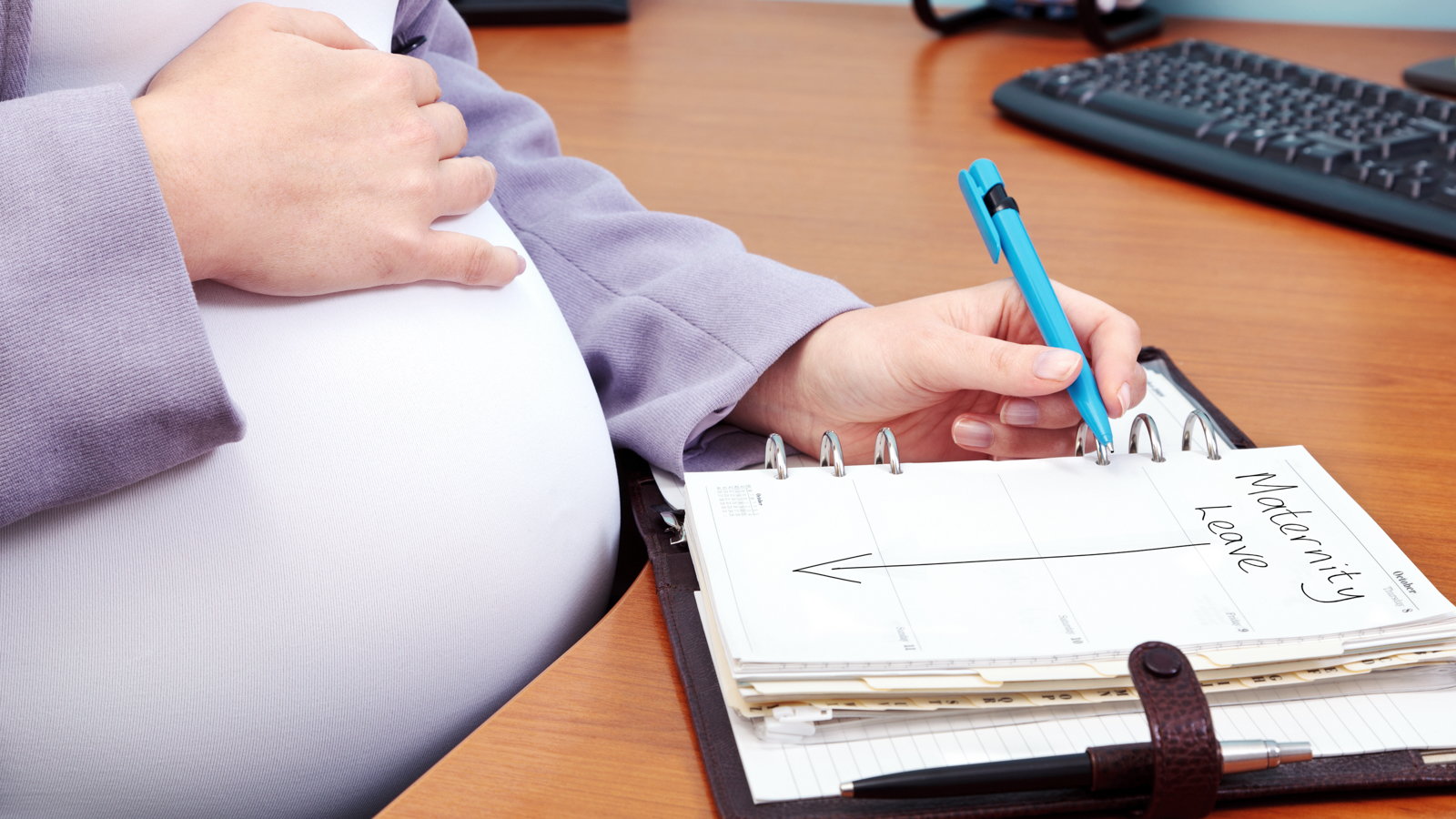 pregnant mom writing in day planner