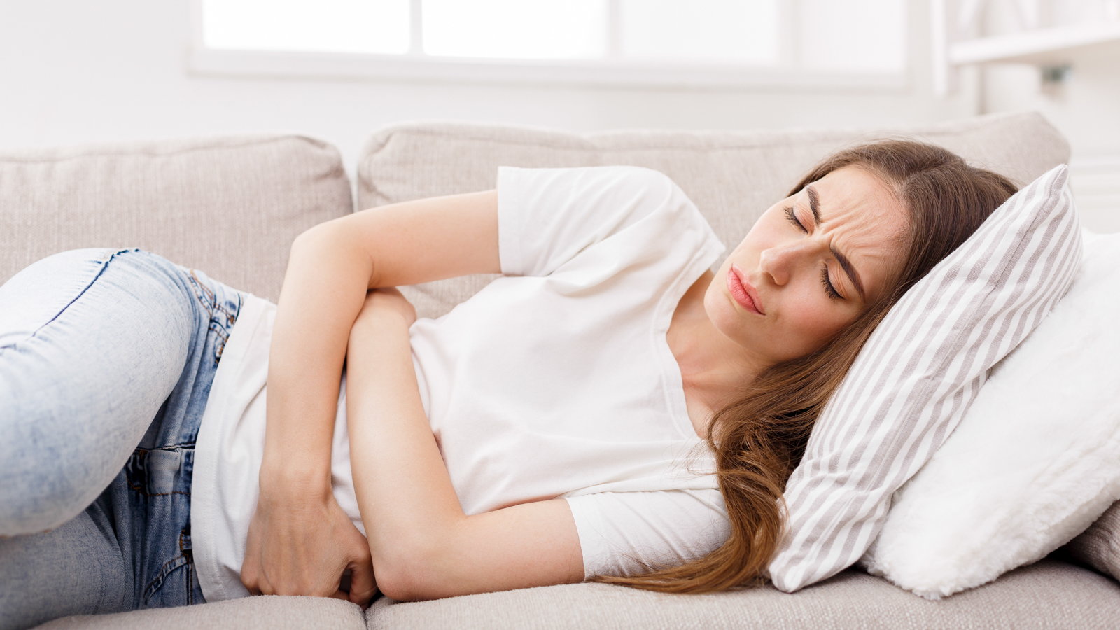 woman laying on the couch having pain