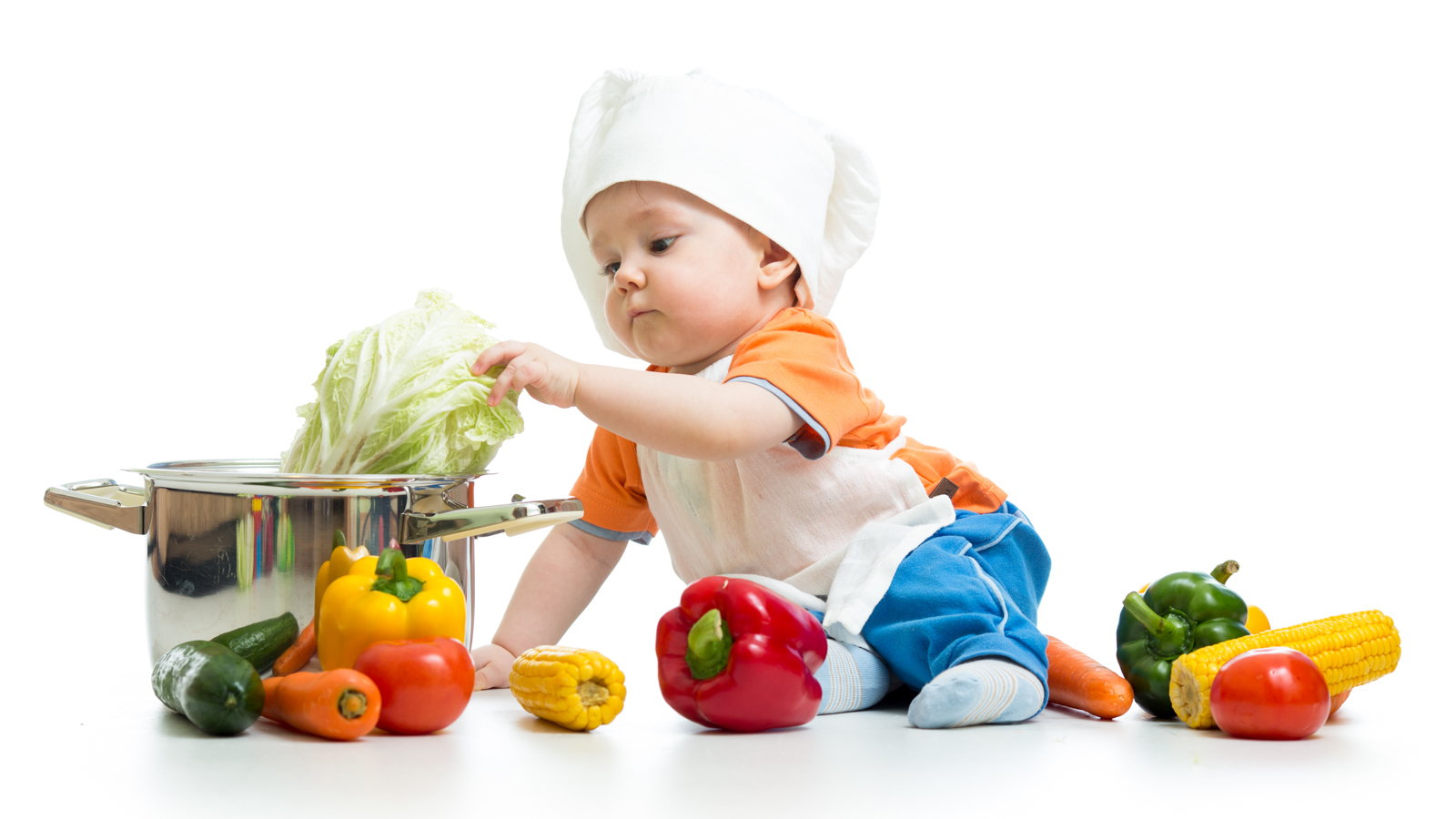baby wearing chef's hat putting vegetables in pot