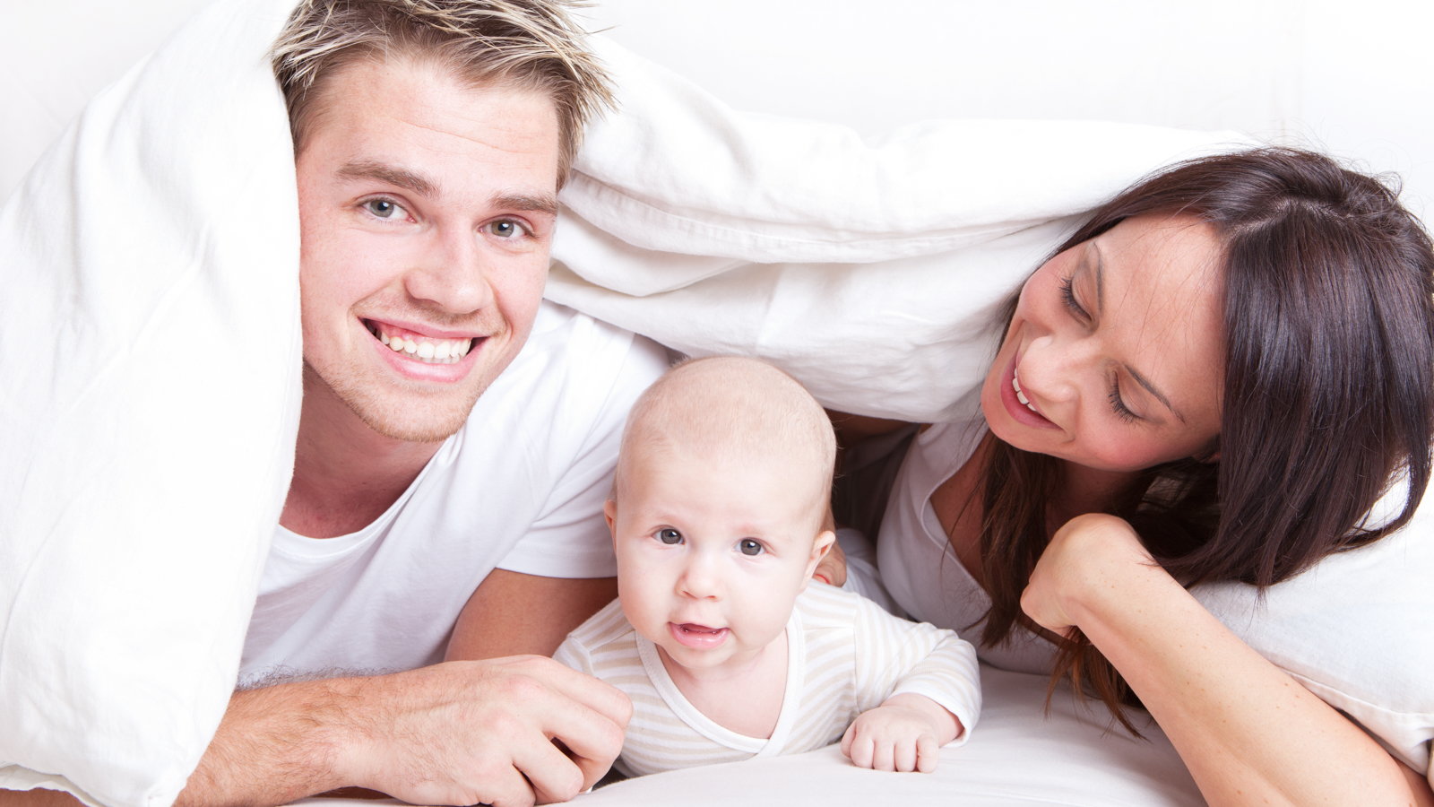 family in bed with baby