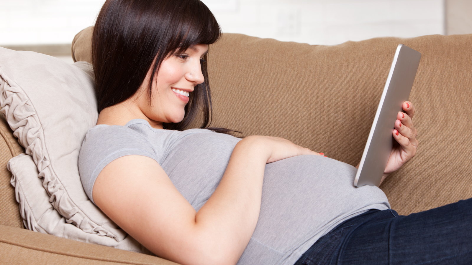 pregnant woman holding tablet