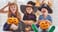 children in Halloween costumes holding pumpkins