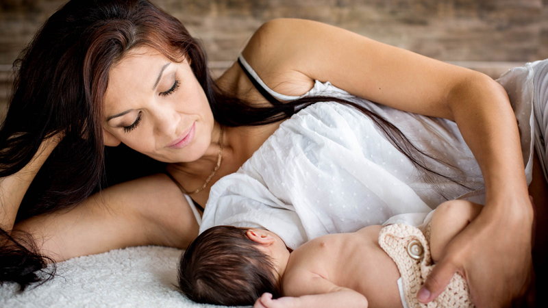 Mother lying on side breastfeeding baby