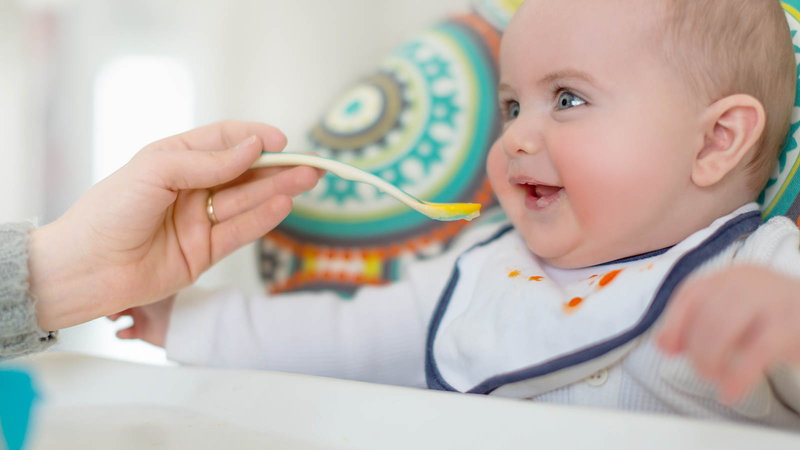 baby eating food off a spoon