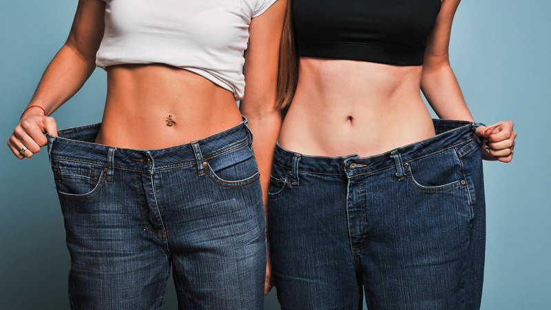 two girls in blue jeans after weightloss