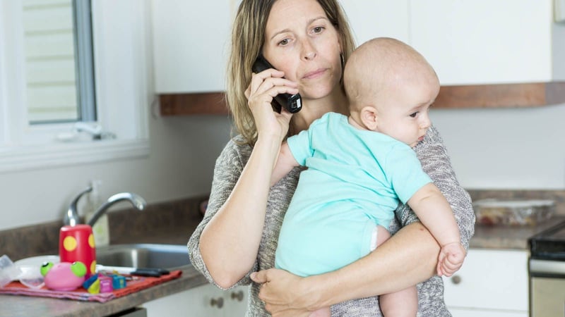 new mom talking on phone while holding baby
