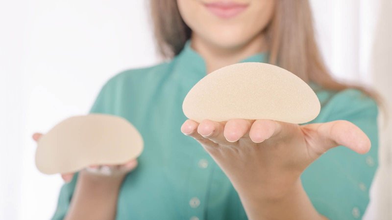 Woman holding breast implants