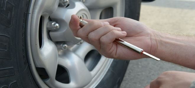 hand with tire pressure tool