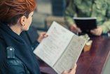 Woman in recovery reading a restaurant menu riddled with alcoholic beverages