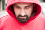 Man in red hoodie thinking about recovery