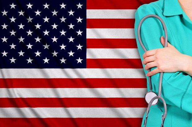 nurse standing in front of flag