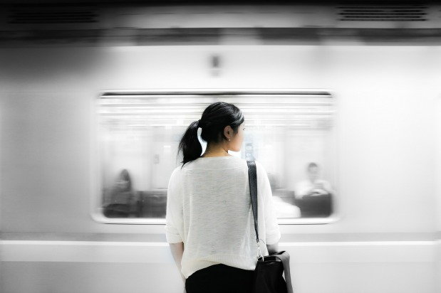 Woman stands still as the train passes her by