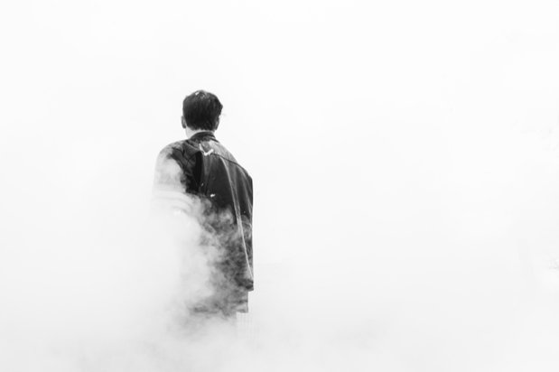 man walking through cloud of smoke
