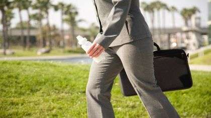 A working mom holding a briefcase and a bottle.