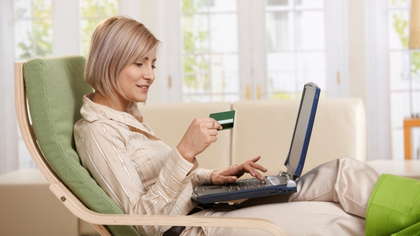 Woman working on her laptop while drinking coffee.