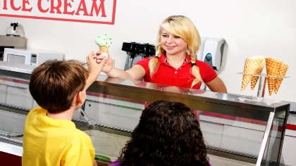A teenage girl working in an ice cream shop. 