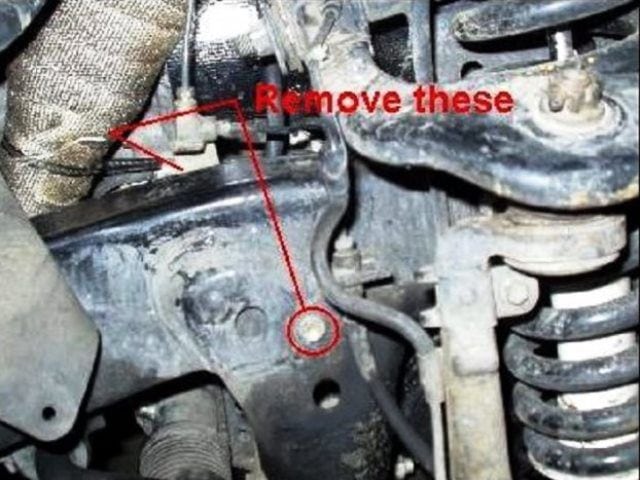Remove the two 12 mm bolts that hold the brake line in place