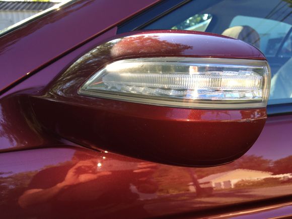 There is a scratch on the outside edge of the driver side side view mirror.