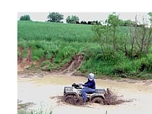 This is another picture of me on my foreman in my pond on my 27 acre farm doin a little mud running.The field in the background is our hay field.